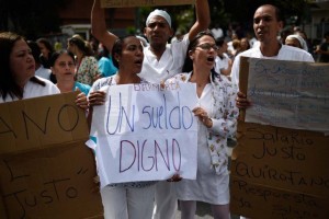 Una enfermera sostiene una pancarta que dice “Salario Digno” durante una protesta por la falta de medicamentos, suministros médicos y malas condiciones en los hospitales, en Caracas el 26 de junio de 2018