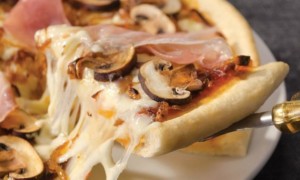 Pizza de hongos cremini, cebolla caramelizada y prosciutto