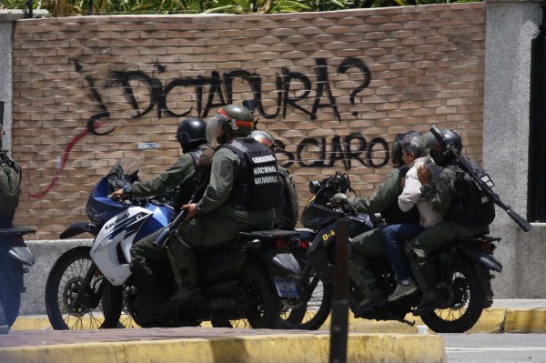La Guardia Nacional Bolivariana reprimiendo a manifestantes en una marcha en Venezuela (Photo by Federico PARRA / AFP)