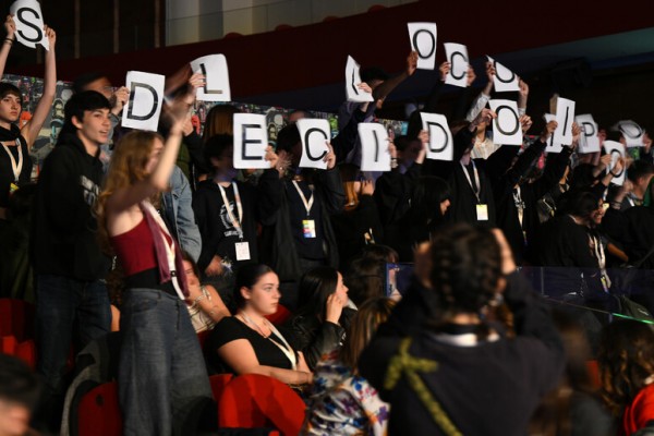  Los estudiantes exhiben carteles durante el discurso de la ministra