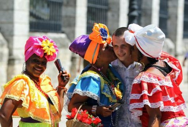 Un turista rodeado de cubanas con ropas típicas. El &quot;deshielo&quot; desató un boom del turismo en la Isla en 2016.