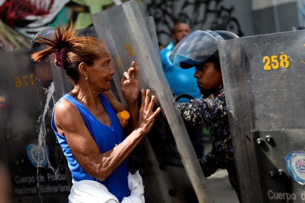 Una mujer es reprimida por la PNB durante una protesta por comida en la avenida Fuerzas Armadas en Caracas este 28 de diciembre 2017