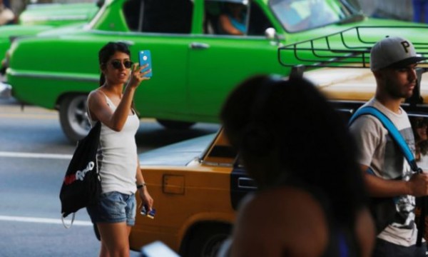 Una mujer usa Internet en su teléfono móvil en un punto de acceso en La Habana, Cuba, el 10 de julio de 2018.