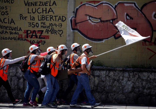 Voluntarios cargan a un herido durante una protesta en Caracas, Venezuela