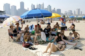 Una familia intenta atemperar el calor a orillas del East River en Brooklyn, arde Nueva York