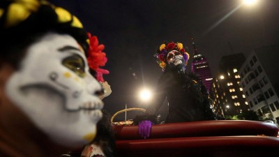 Mexicans don skeleton disguises for a pre-Day of the Dead parade