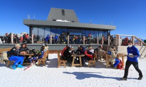 Uno ski bar ai piedi di una pista da sci inondata dal sole a Moena