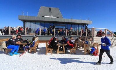 Uno ski bar ai piedi di una pista da sci inondata dal sole a Moena