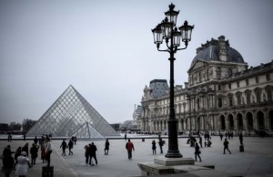 La gente camina hacia la Pirámide del Louvre en París